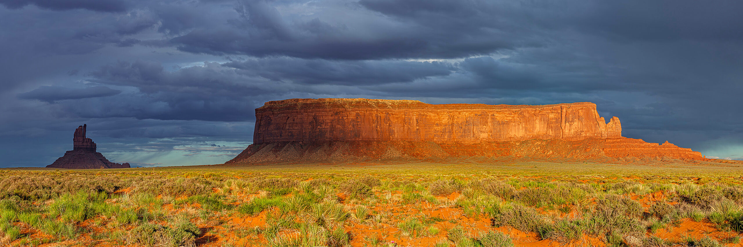 Monument Valley Region Sunrise One of the many enormous (1000+ foot) mesas that dominate the landscape of the Monument Valley region, on the Utah / Arizona...