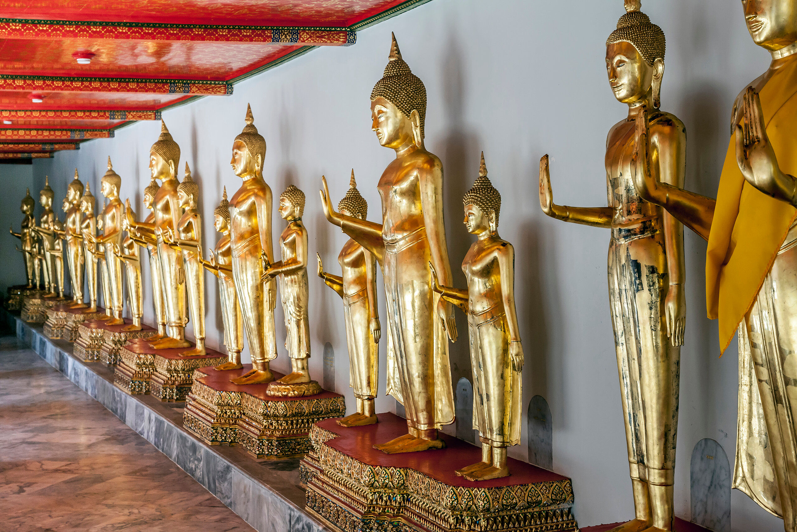 Standing Buddhas A row of standing, golden Buddhas found in Wat Pho, home of the famous Reclining Buddha, in Bangkok, Thailand.